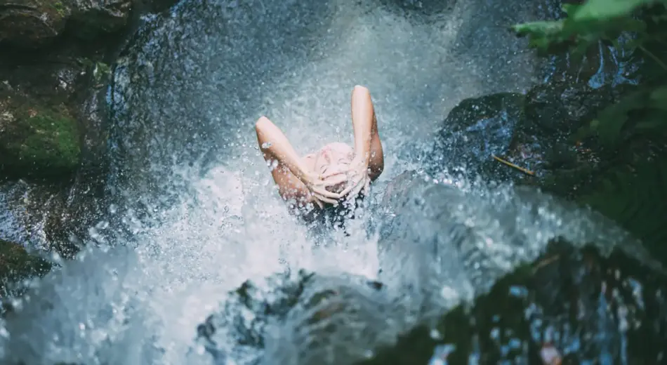 Frau unter einem Wasserfall